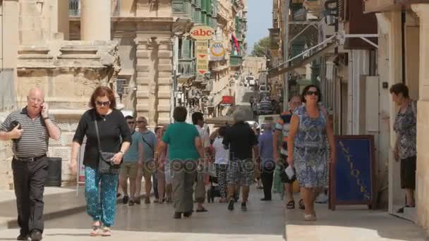 CENTRO DE LA CIUDAD DE MALTA CAPITAL VALLETTA, CALLE PEDESTRIANO - JULIO 2016: Muchas personas turísticas y locales de compras en el centro antiguo lleno de tiendas, cafetería, farmacia niños jugando, amigos charlando — Vídeo de stock