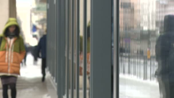 Pessoas anônimas andando na rua de uma cidade com reflexos de vitrine — Vídeo de Stock