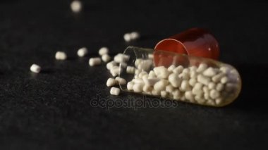 Demonte sindirim enzimi kapsül bir siyah arka plan üzerinde döner.