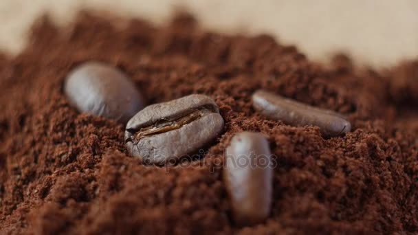 Kaffeebohnen auf gemahlenem Kaffee. — Stockvideo