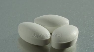 Üç beyaz hap bir plaka üzerinde döndürme