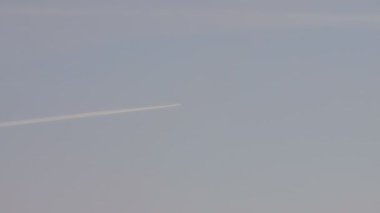 Mavi gökyüzünde yoğunlaşma iz bırakarak uçak uçan.