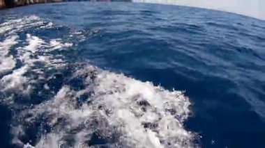 Küçük tekne arkasında su izleme.