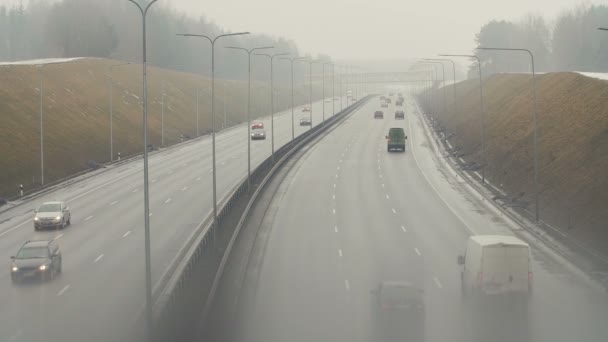 Automobiles cars drive on foggy city road. Dangerous driving conditions in winter season. — Stock Video