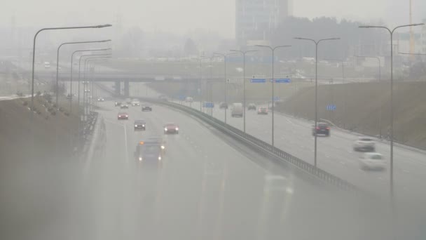 Automobiles voitures conduisent sur la route de la ville brumeuse. Conditions de conduite dangereuses en hiver . — Video