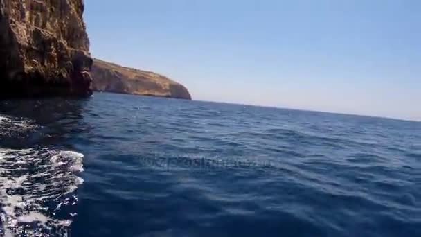 Widok z przodu łodzi z koło ratunkowe, pływające na błękitne morze. — Wideo stockowe