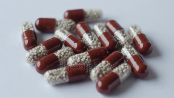 Medicinska piller placeras på roterande bord, sköt med vit sömlös bakgrund — Stockvideo