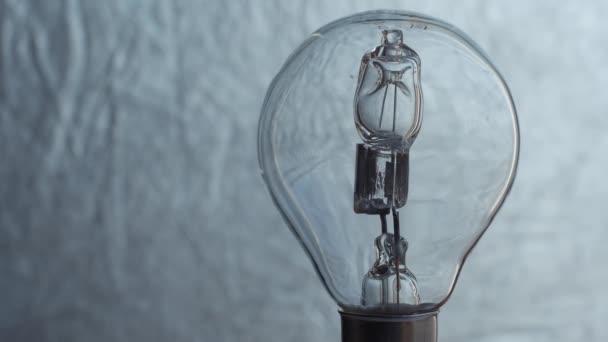 Close Up of light bulb over silver background. Electricity. — Stock Video