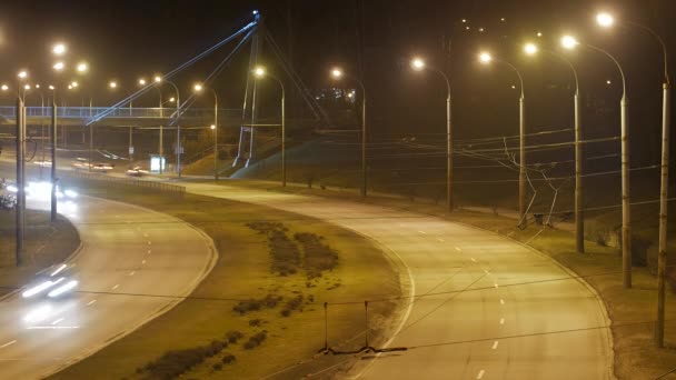 Časová prodleva, světelné stopy městské dopravy na pozadí budovy. — Stock video