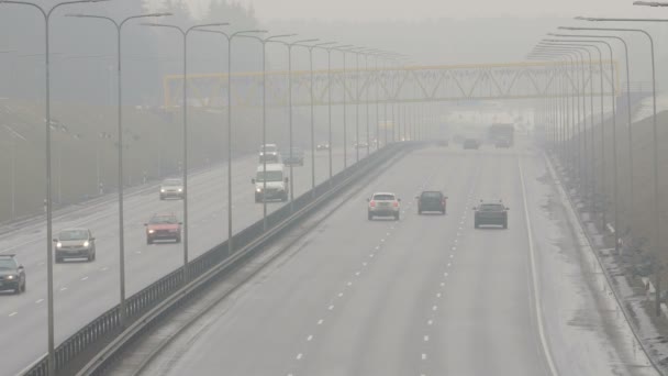 Vilnius, Litauen - 30. September 2015: Autos fahren am 30. September 2015 in Vilnius, Litauen, auf einer nebligen Stadtstraße. Gefährliche Fahrbedingungen in der Herbstsaison. Statischer Schuss. 4k — Stockvideo