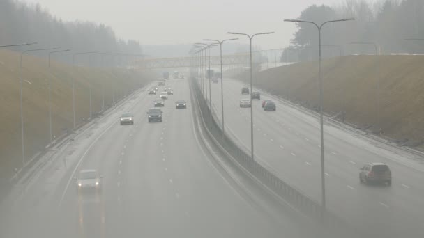 VILNIUS, LITHUANIA - SEPTEMBER 30, 2015: automobiles cars drive on foggy city road on September 30, 2015 in Vilnius, Lithuania. Dangerous driving conditions in autumn season. Static shot. — Stock Video