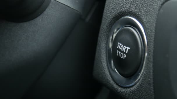 Images macro d'une conductrice appuyant sur un bouton de démarrage et d'arrêt d'un moteur d'une voiture . — Video