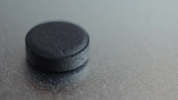Tabletki węgla aktywowanego, na białym tle na podłoże metaliczne. — Wideo stockowe