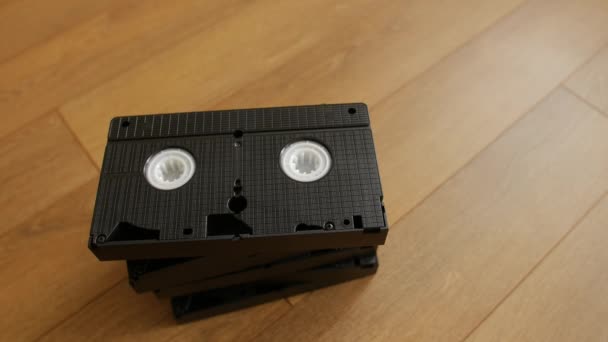 Stack of VHS video tape cassette over wooden background, top view. — Stock Video