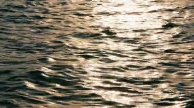 Hafif meltem Günbatımı ile sıvı bakır gibi bakıyor, sakin parıldayan Gölü su ripples.