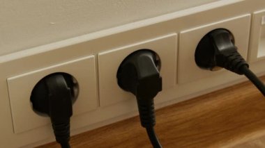 Adam el koyarak fişi elektrik prizine yakın çekim.