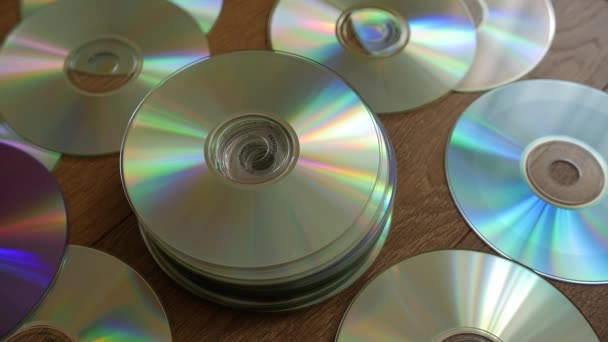 Discos ópticos que caem sobre pilhas de DVDs ou CDs . — Vídeo de Stock