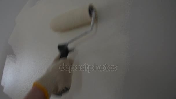 Pintura de una pared desnuda con un rodillo de pintura con pintura blanca . — Vídeos de Stock