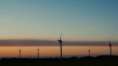 Rüzgar türbinleri çiftlikleri ile gün batımında ışık ışınları