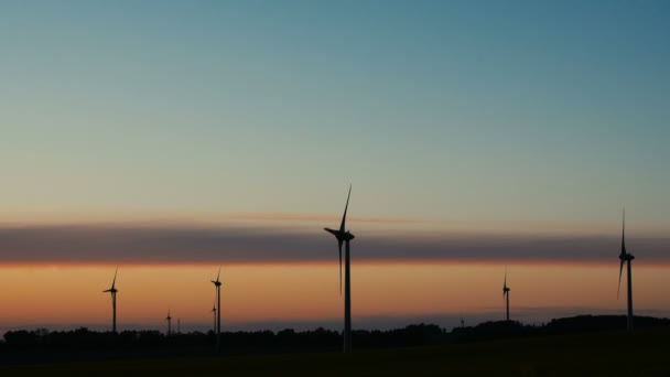 Windturbines boerderijen met stralen van licht bij zonsondergang — Stockvideo