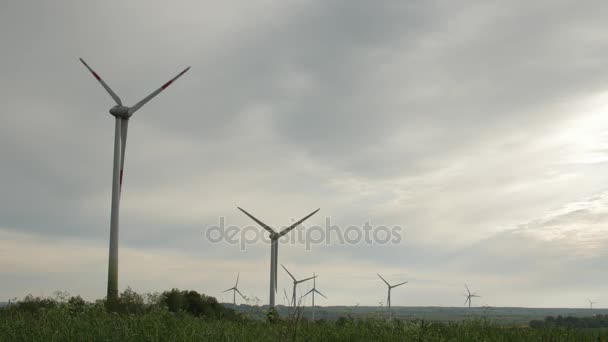Turbiny wiatrowe na białym tle na tle zachmurzonym niebie — Wideo stockowe