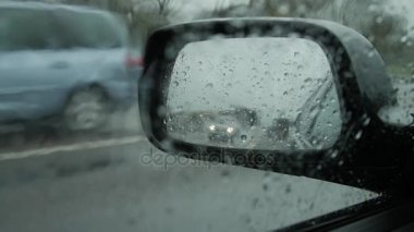 Yan dikiz aynası yağışlı hava, ıslak arabalar yol.