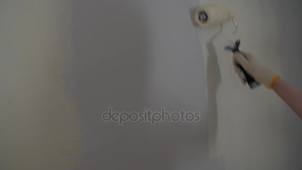 Målning ut en kala väggen med en paint roller med vit färg. — Stockvideo