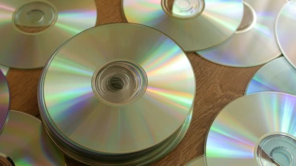 Discos ópticos que caem sobre pilhas de DVDs ou CDs . — Vídeo de Stock