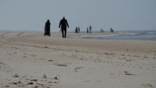 Silhouettes de personnes méconnaissables marchant sur la plage, ralenti . — Video