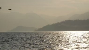 Dağ ve göl batan güneşin akşam ışığında.
