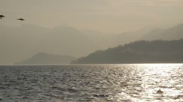 Bergen en meer in het avondlicht van de ondergaande zon. — Stockvideo