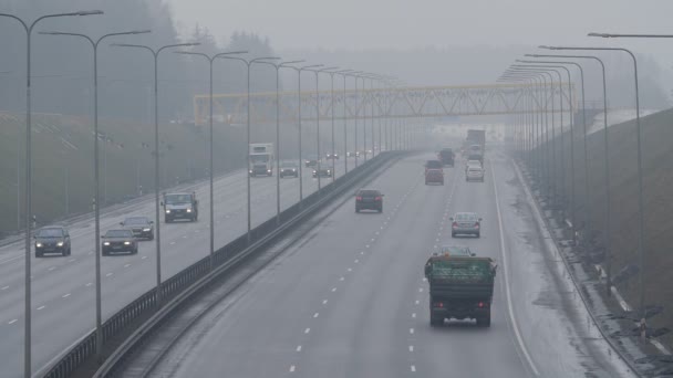 VILNIUS, LITUÂNIA - SETEMBRO 30, 2015: os automóveis dirigem na estrada nebulosa da cidade em 30 de setembro de 2015 em Vilnius, Lituânia. Condições de condução perigosas na época de Outono. Tiro estático . — Vídeo de Stock