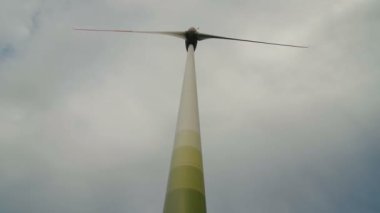 Rüzgar Türbini elektrik üretmek için yenilenebilir enerji kullanma fırtınalı bulutlu gökyüzü üzerinde.