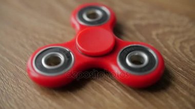 Kırmızı kıpır spinner iplik ahşap bir masa üzerinde.
