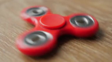 Kırmızı kıpır spinner iplik ahşap bir masa üzerinde.