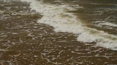 Sonları kayalar hakkında denizde dalgalar. Küçük dalgalar ve yuvarlak taşlar.