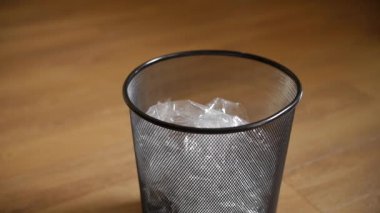 Kağıtları kahverengi kat zemin üzerine metal çöp kutusu içine atmak.