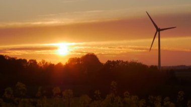 Rüzgar türbinleri çiftlikleri ile gün batımında ışık ışınları