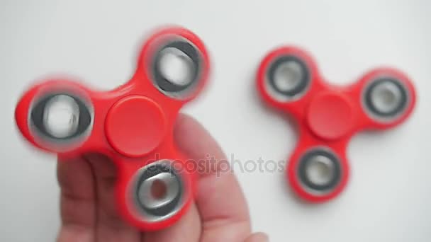 Imagens de perto de uma mão de pessoas brincando com o fidget spinner, isolado em um fundo branco — Vídeo de Stock