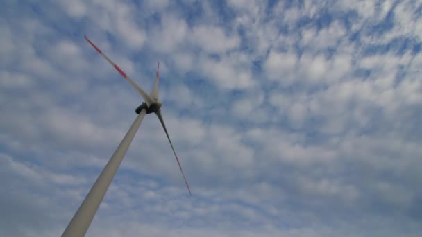 Die Rotorblätter der Windstation drehen sich gegen den schönen blauen Himmel. — Stockvideo