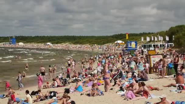 PALANGA, LITHUANIA - July, 29, 2017. Люди отдыхают, загорают и купаются на пляже Паланги в жаркий летний день . — стоковое видео