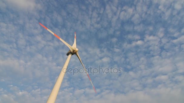 Die Rotorblätter der Windstation drehen sich gegen den schönen blauen Himmel. — Stockvideo