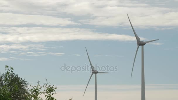 风力涡轮机农场，电力发电机，在多云的天空背景上的字段. — 图库视频影像