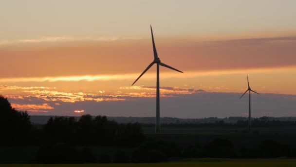 Windturbines boerderijen met stralen van licht bij zonsondergang — Stockvideo