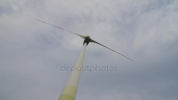 Wind turbine over stormy cloudy sky using renewable energy to generate electrical power. — Stock Video