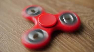 Kırmızı kıpır spinner iplik ahşap bir masa üzerinde.