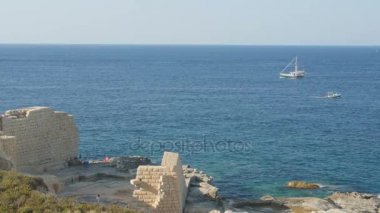 Deniz Manzaralı. Deniz ve gökyüzü Panoraması. Uzakta yalnız kargo gemisi. Beton deniz güçlendirilmesi.