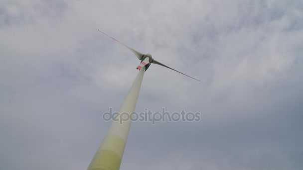 Wind turbine over stormy cloudy sky using renewable energy to generate electrical power. — Stock Video