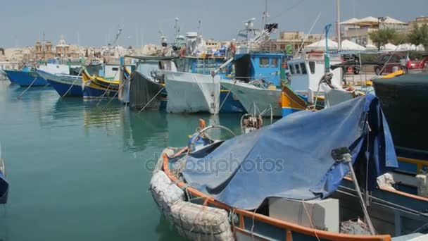 MARSAXLOKK, MALTE - 6 juillet 2016 : Belle architecture de village de pêcheurs avec des bateaux colorés à l'ancre dans une baie — Video