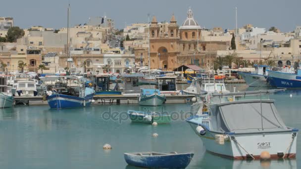 Marsaxlokk, Μάλτα - 6 Ιουλίου 2016: Αρχιτεκτονική της Βαβατσινιάς όμορφο ψαροχώρι με χρωματιστές βάρκες για αγκυροβολημένο σε έναν κόλπο — Αρχείο Βίντεο
